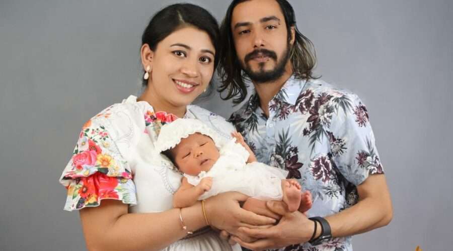 "Happy couple cradling their newborn baby in a heartwarming moment captured by Kat Alora Photography.