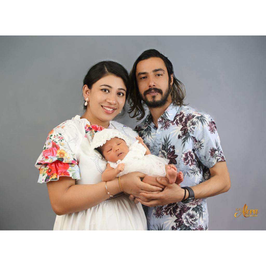 "Happy couple cradling their newborn baby in a heartwarming moment captured by Kat Alora Photography.