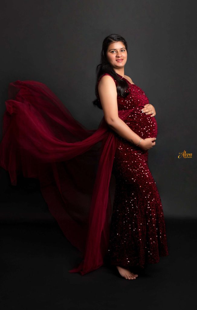 Expecting mother smiling gently while holding her belly