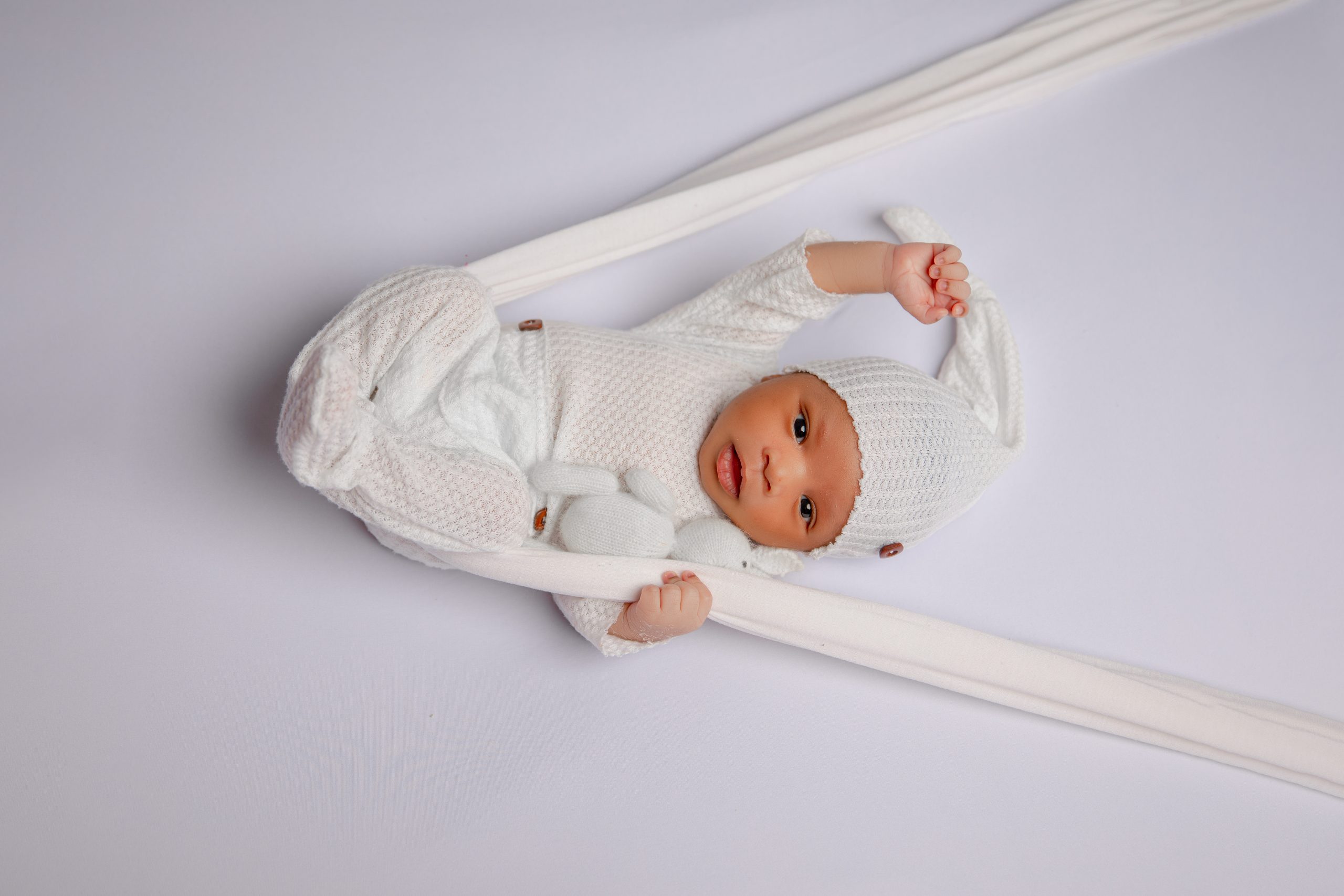 Affordable newborn photography Melbourne by Kat Alora Photography featuring a sleeping newborn baby wrapped in soft neutral tones in Cranbourne North studio
