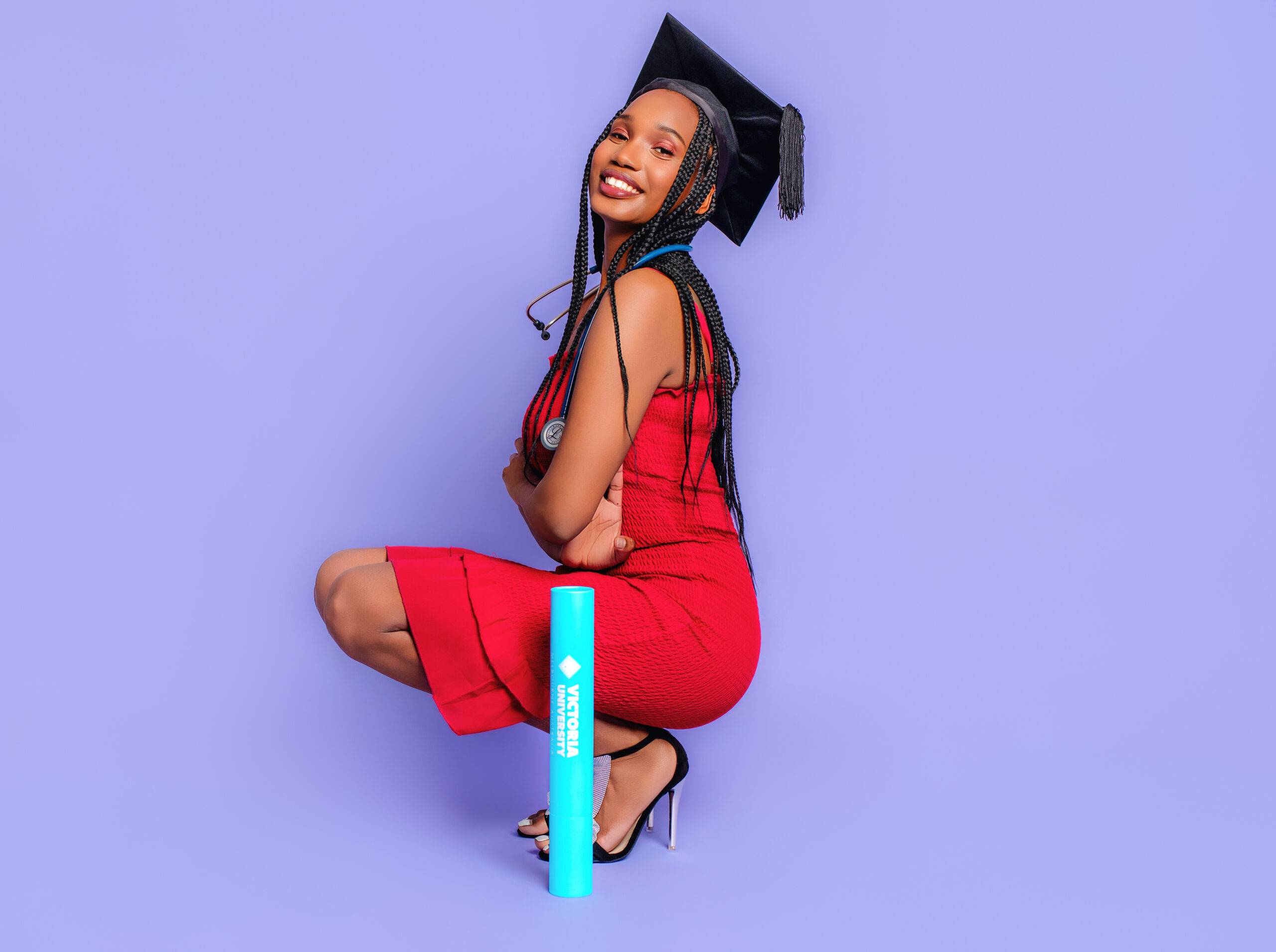 Female graduate posing confidently in studio with graduation cap and sash in Melbourne