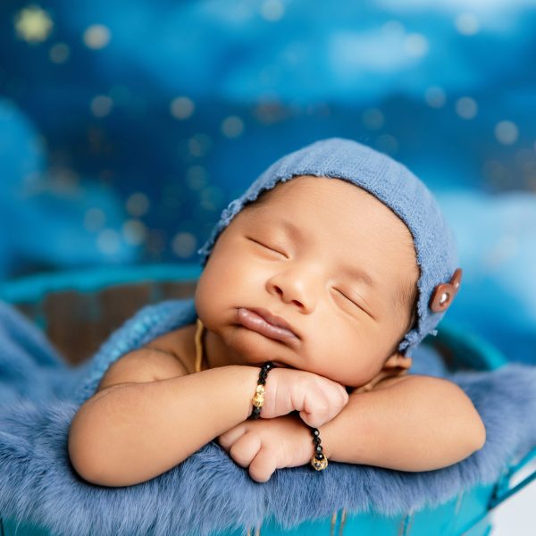 Newborn baby in basket prop during styled photoshoot