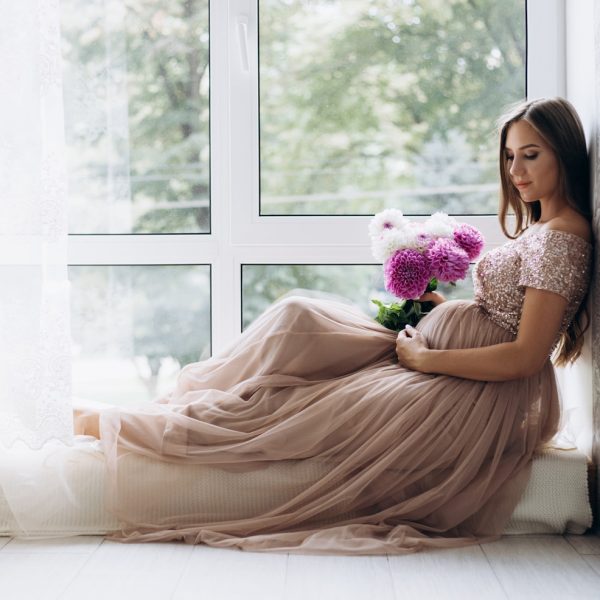 expecting-lady-lies-windowsill-bright-room_8353-8104